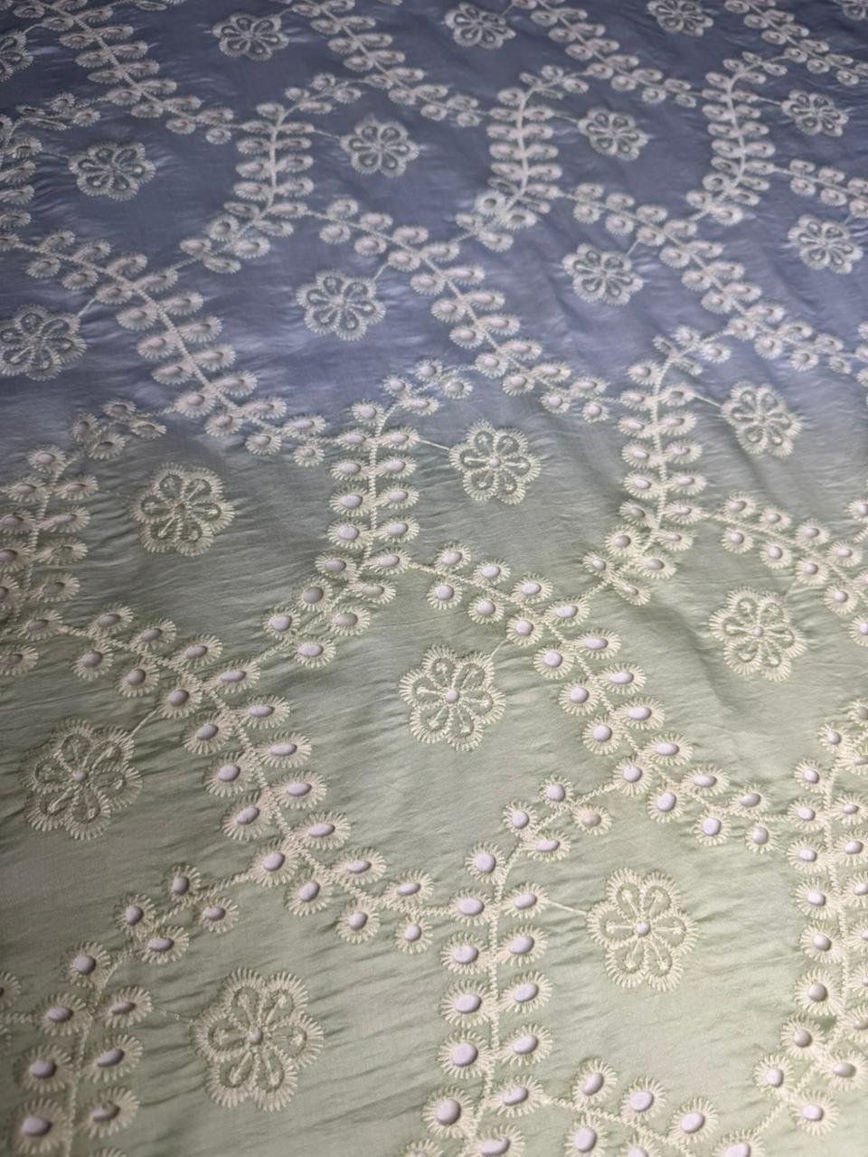 Embroidered fabric with floral patterns on a gradient background