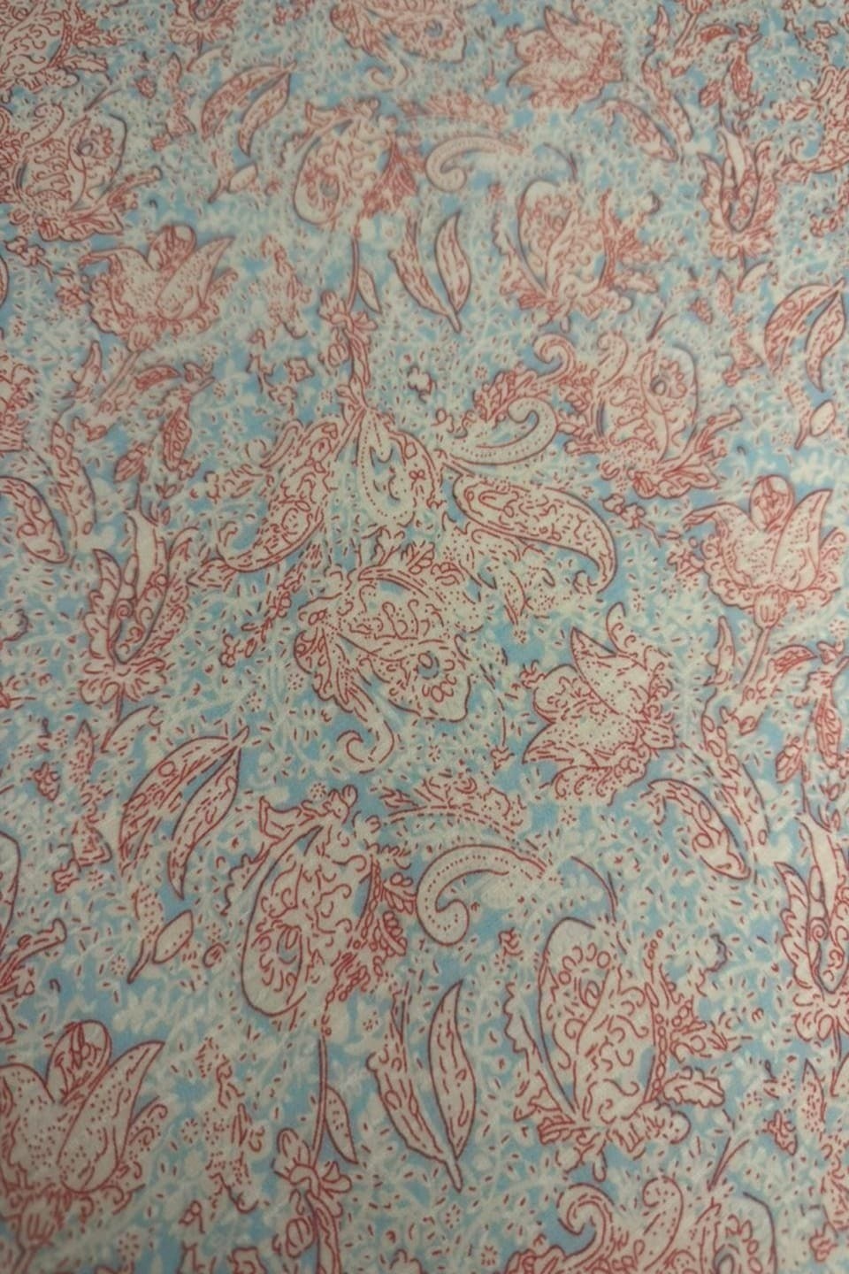 Patterned fabric with red and blue design on a textured background