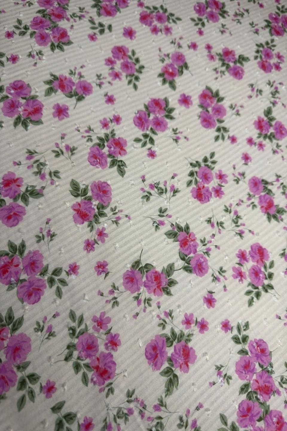 Floral pattern with pink flowers on a textured white background
