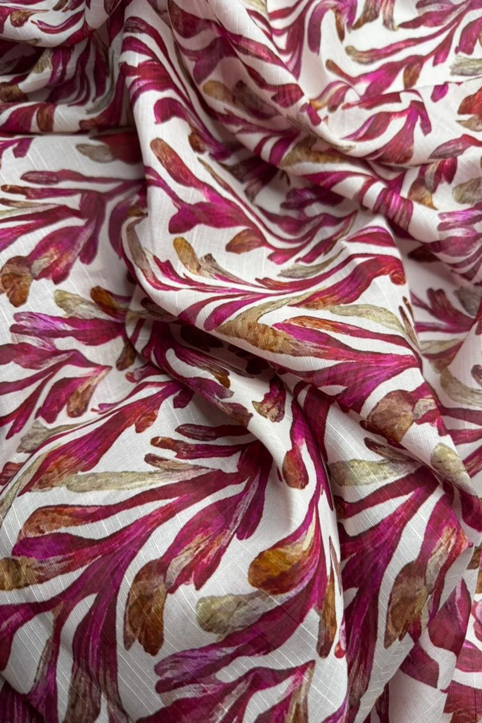 Close-up of fabric with red and brown abstract pattern on white background