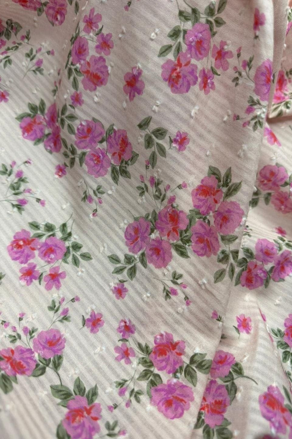 Floral patterned fabric with pink flowers on a white background