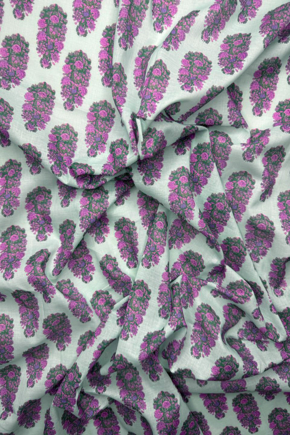 Fabric with purple and green floral pattern on a light gray background