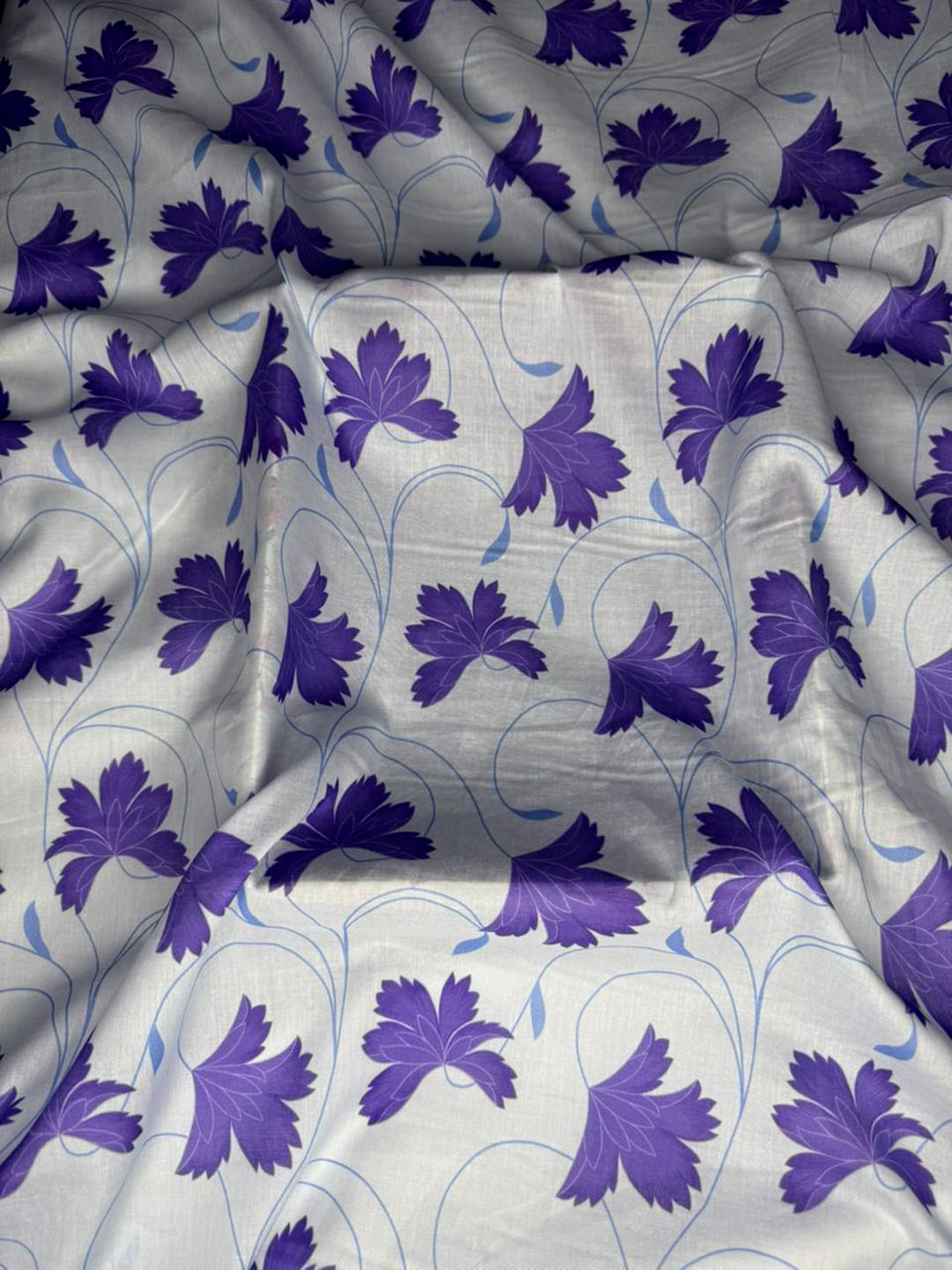 Floral patterned fabric with purple flowers on a white background