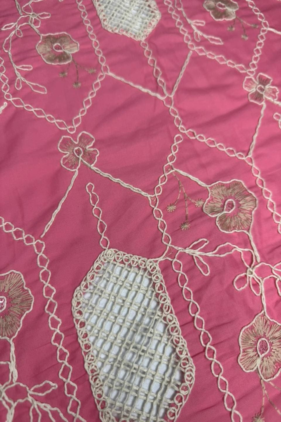 Embroidered fabric with floral patterns on a pink background