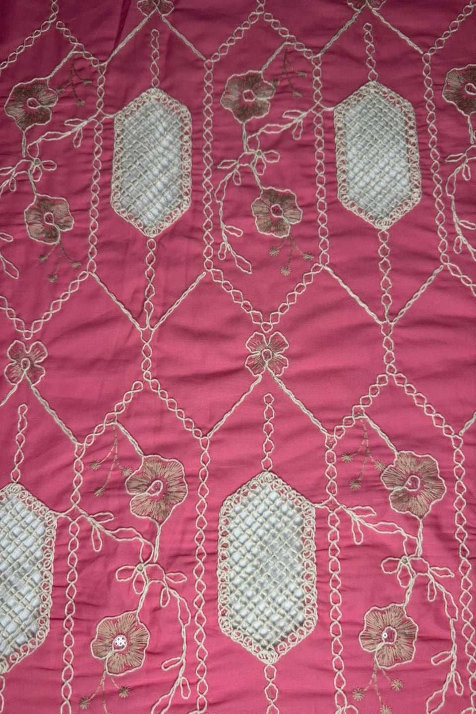 Embroidered fabric with floral patterns on a pink background