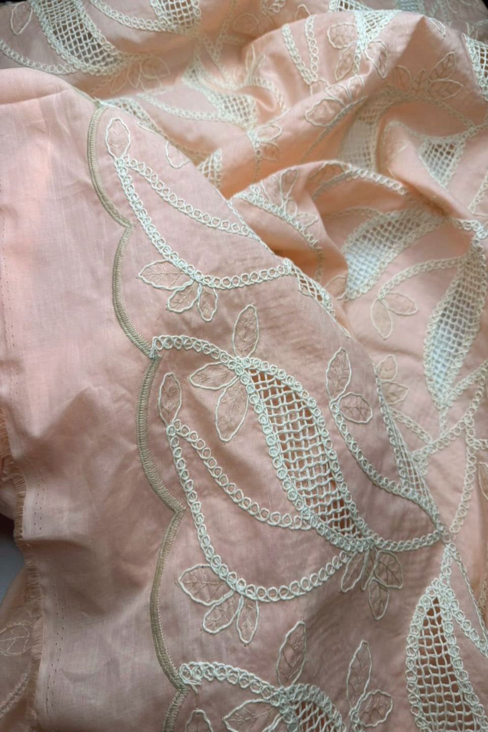 Close-up of pink fabric with intricate white lace detailing