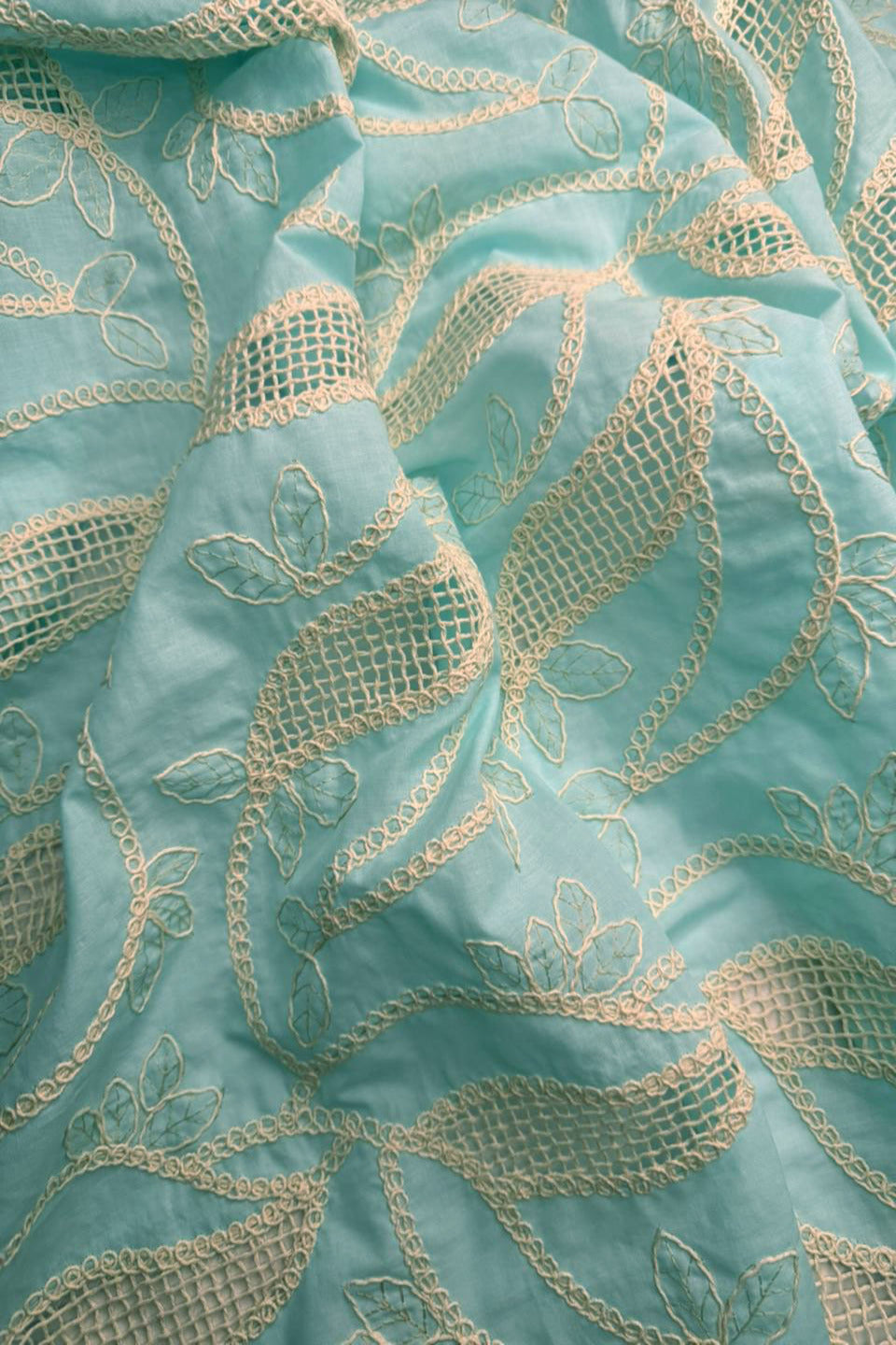 Close-up of turquoise fabric with gold embroidery