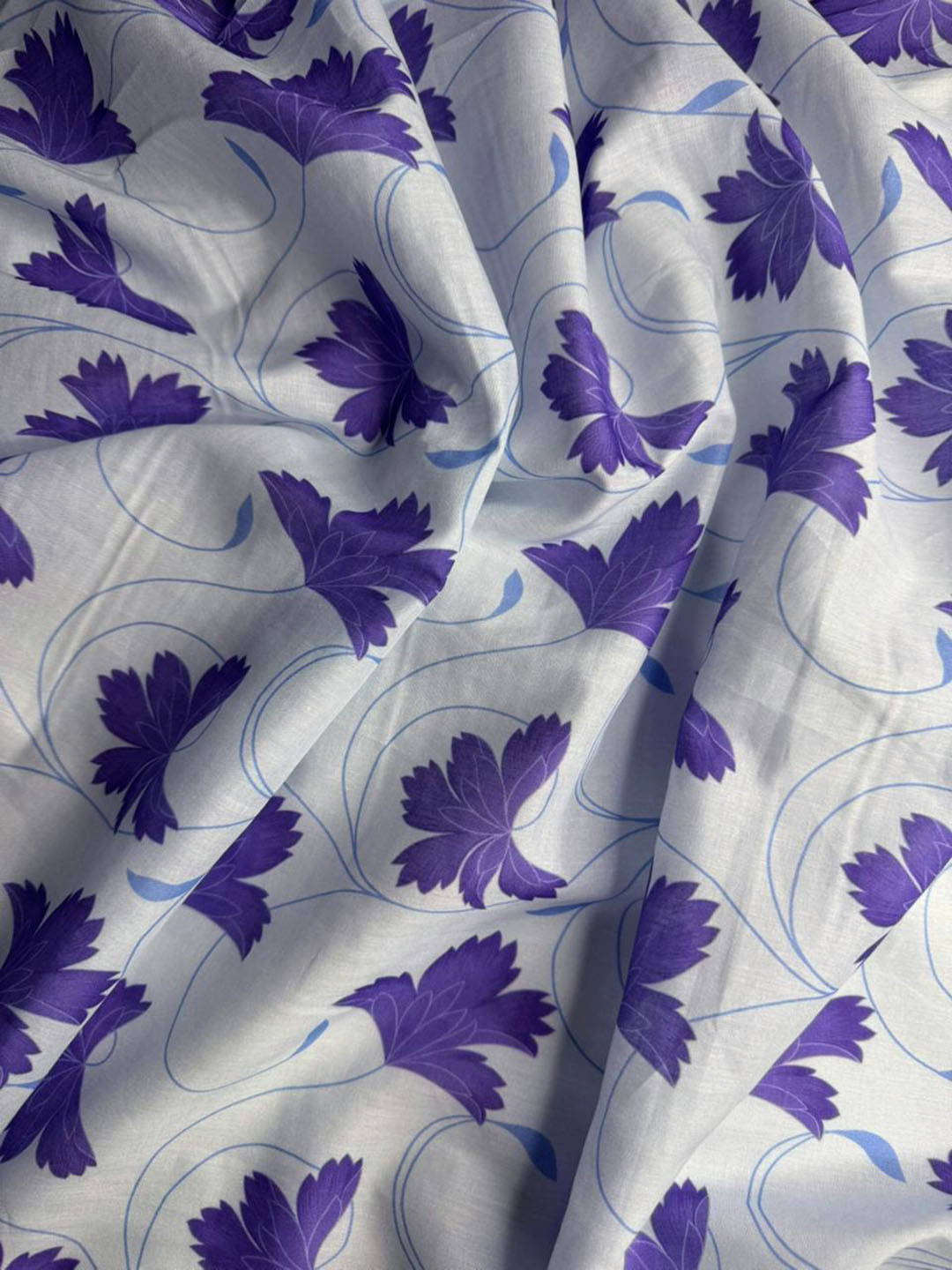 Fabric with purple floral pattern on a white background
