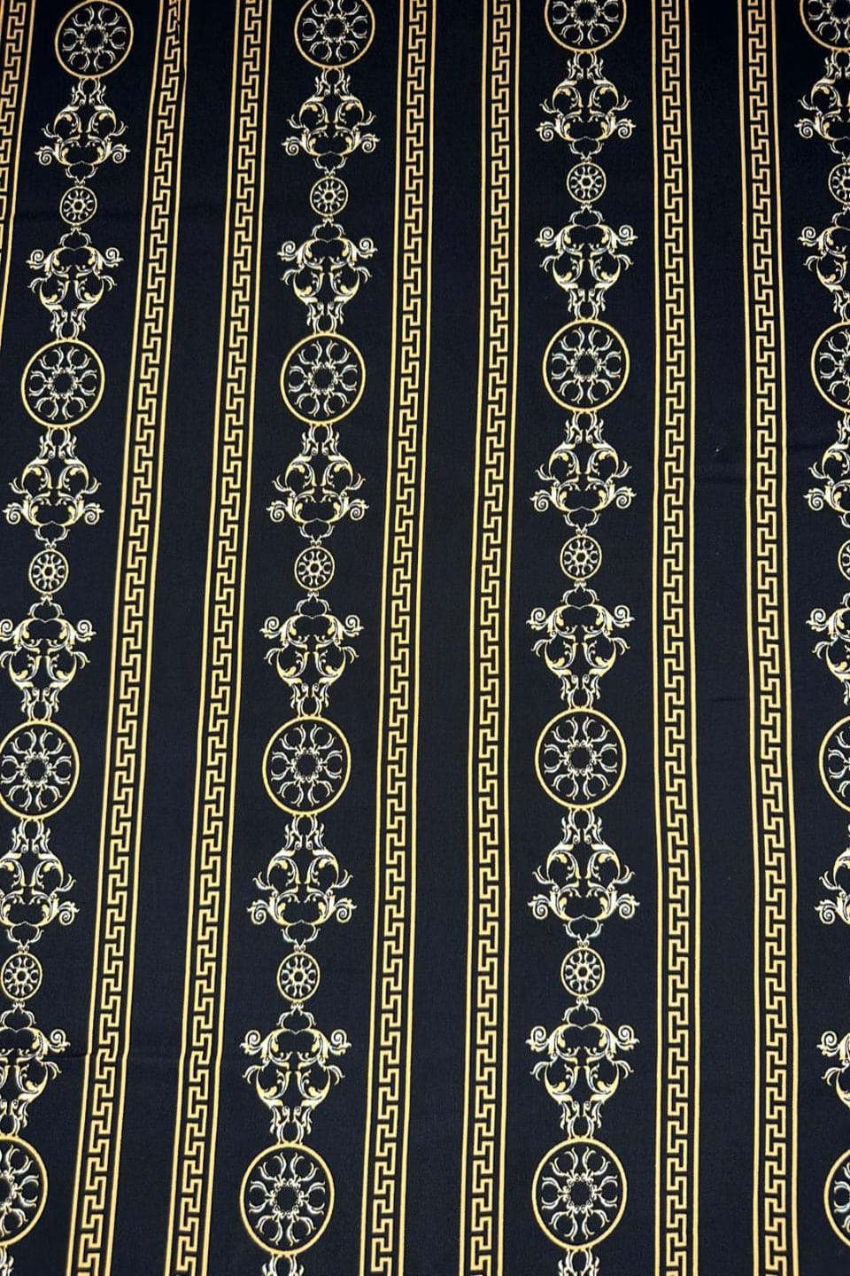 Decorative fabric with intricate gold patterns on a black background