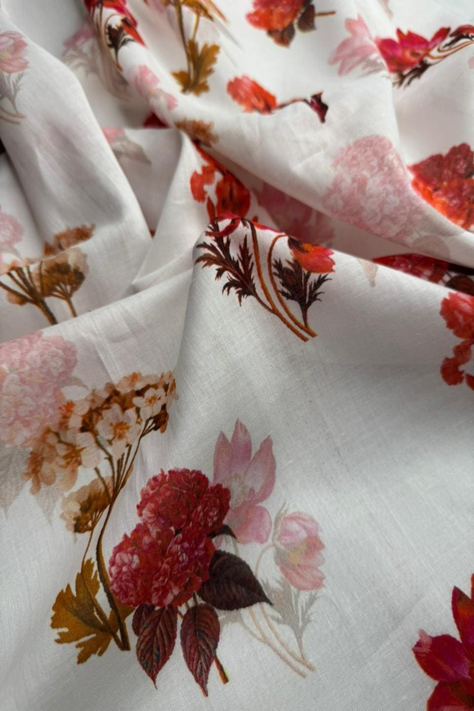 Floral fabric with red, pink, and brown flowers on a white background