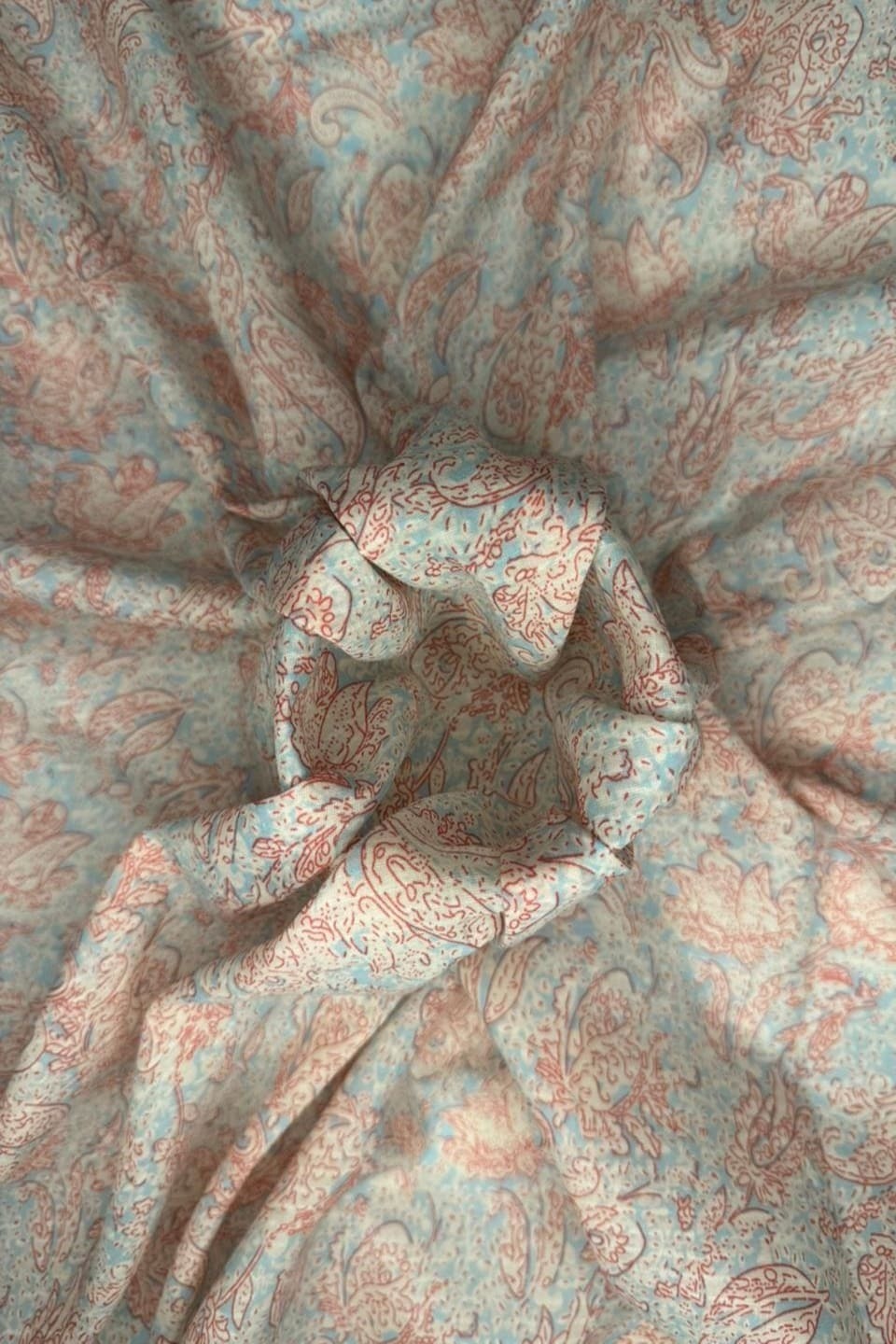 Close-up of patterned fabric with swirling designs in red and blue.
