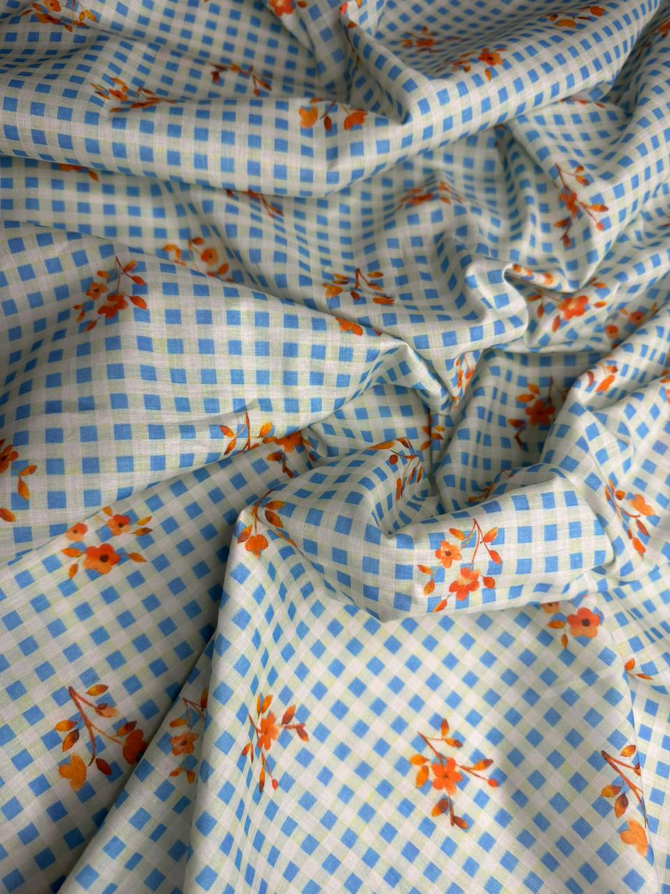 Fabric with blue checkered pattern and orange floral designs