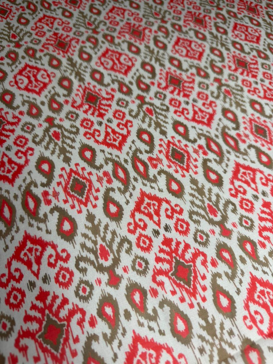 Patterned fabric with red and brown geometric design on a white background