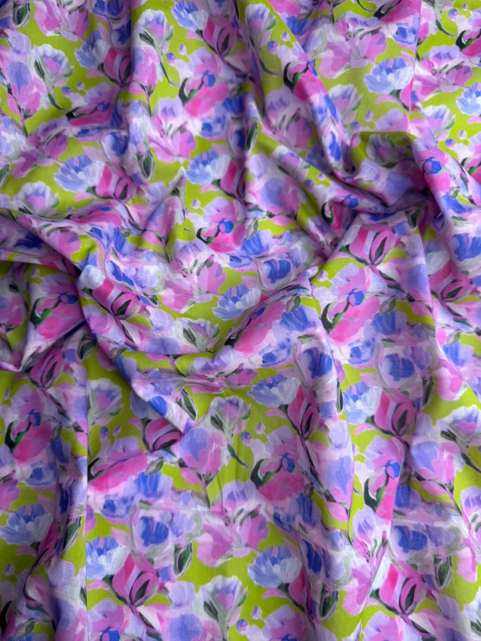 Floral fabric with pink and blue flowers on a green background