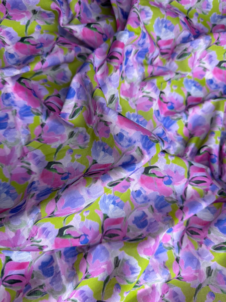 Floral fabric with pink, purple, and green colors on a green background