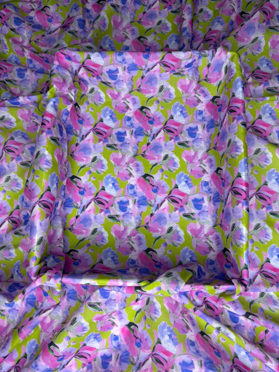 Floral patterned fabric with pink and purple flowers on a green background