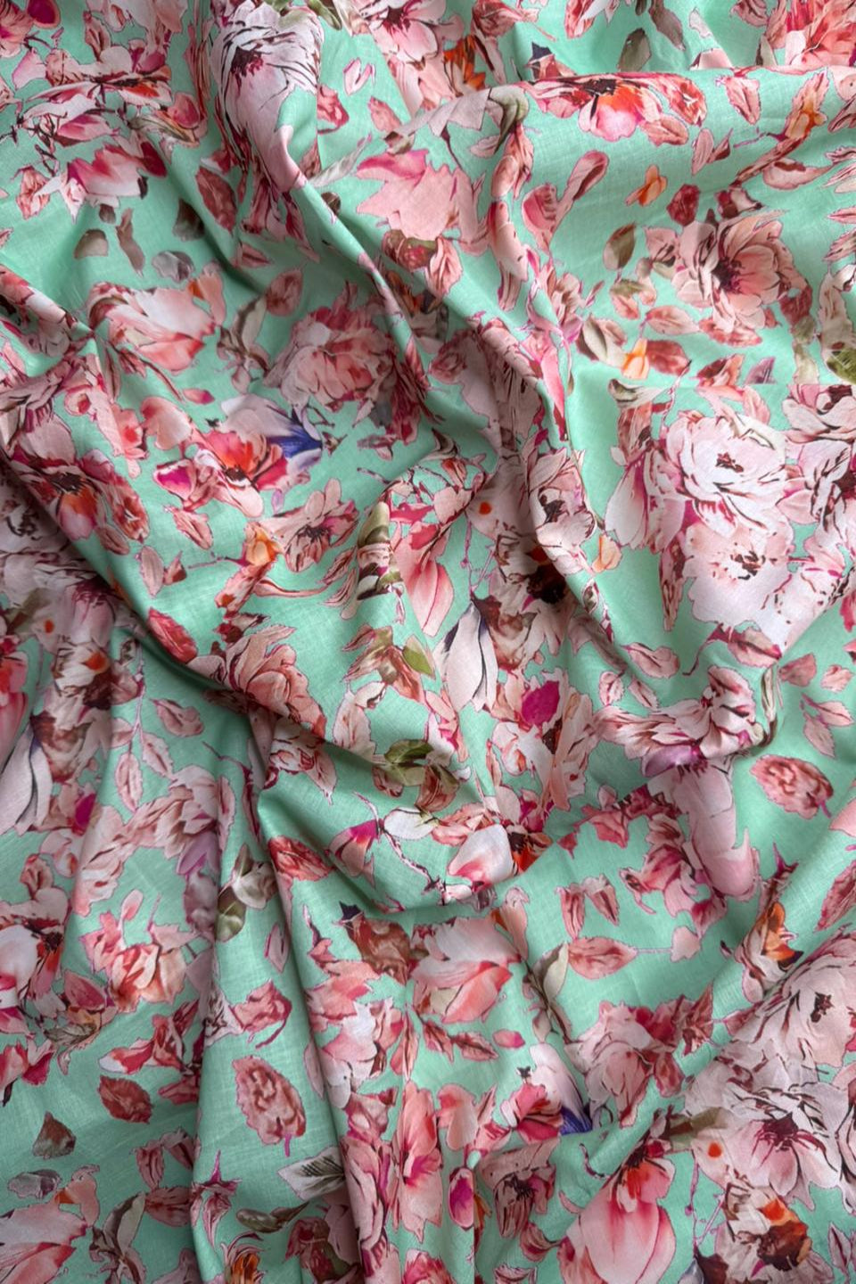 Floral fabric with pink and red flowers on a green background