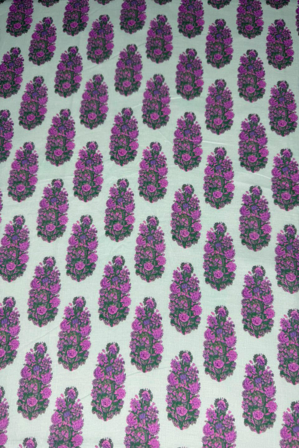 Patterned fabric with purple and green design on a light background