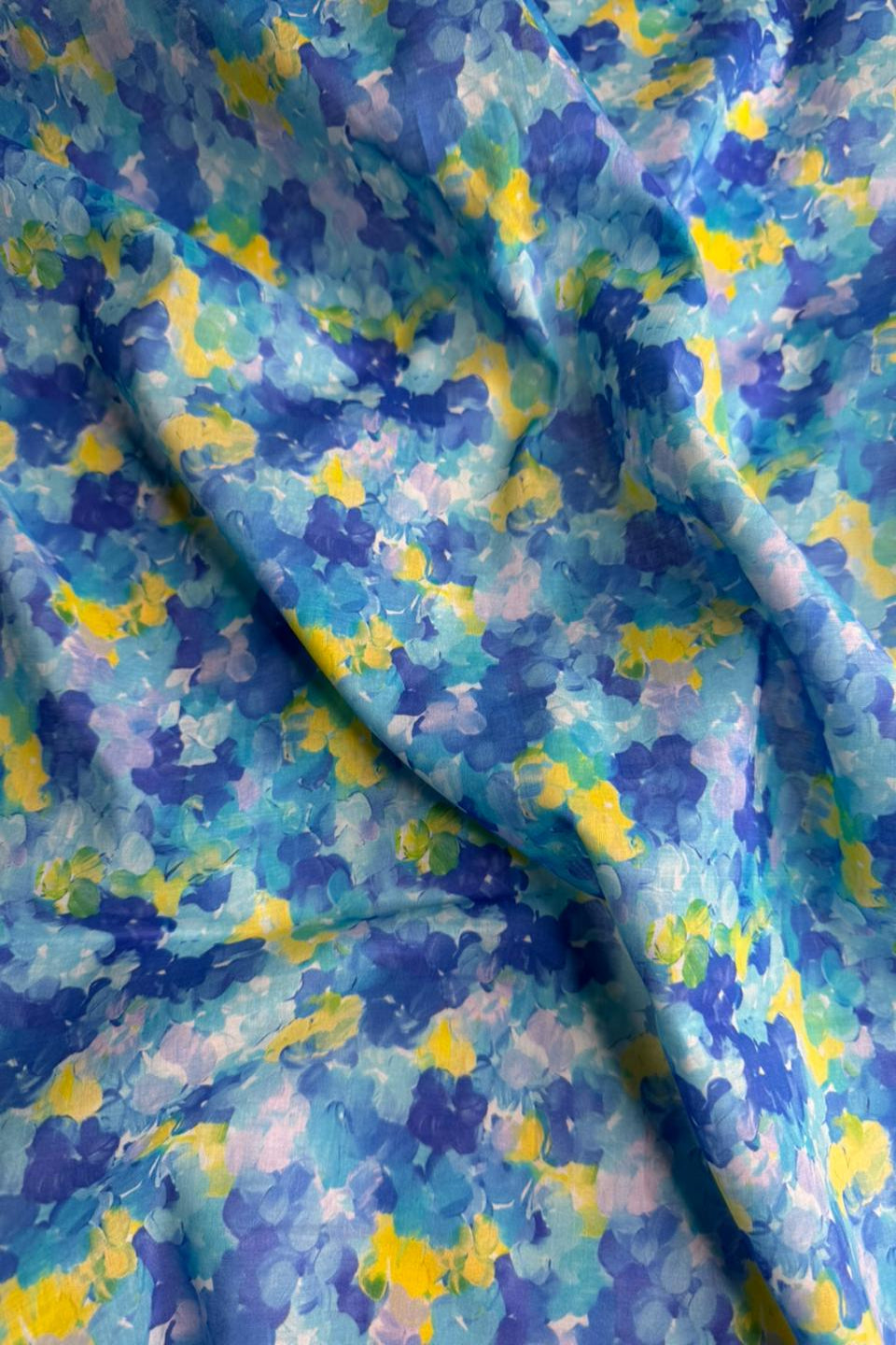 Colorful abstract patterned fabric with blue, yellow, and purple colors.
