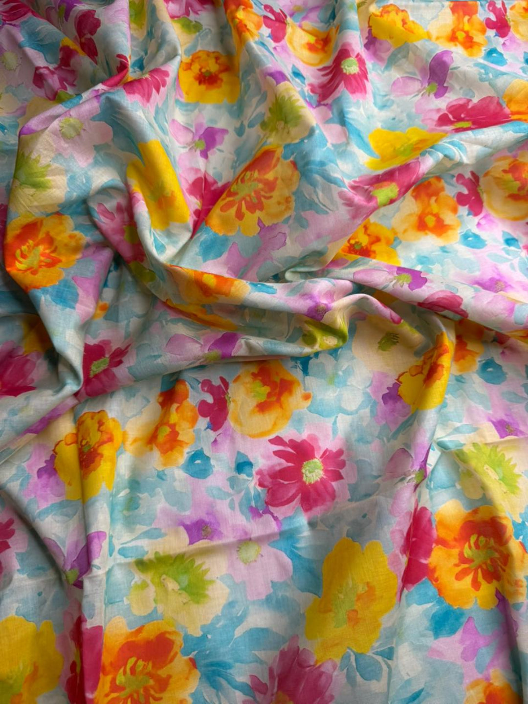 Colorful floral fabric with a pattern of pink, yellow, and blue flowers.