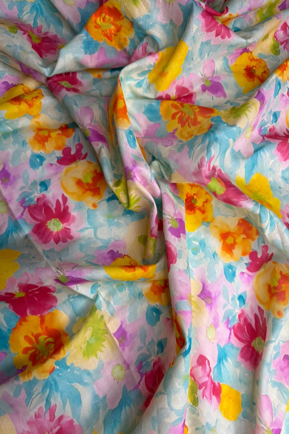 Colorful floral fabric with a mix of pink, yellow, blue, and green flowers.