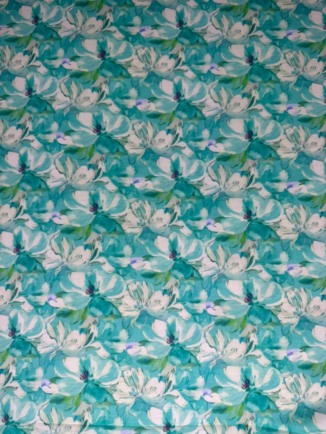 Floral patterned fabric with white flowers on a teal background