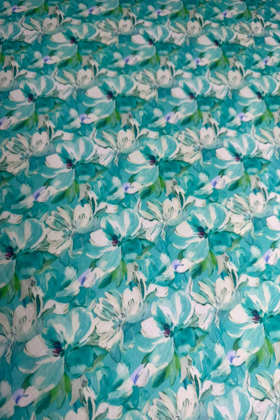 Floral patterned fabric with white flowers on a teal background