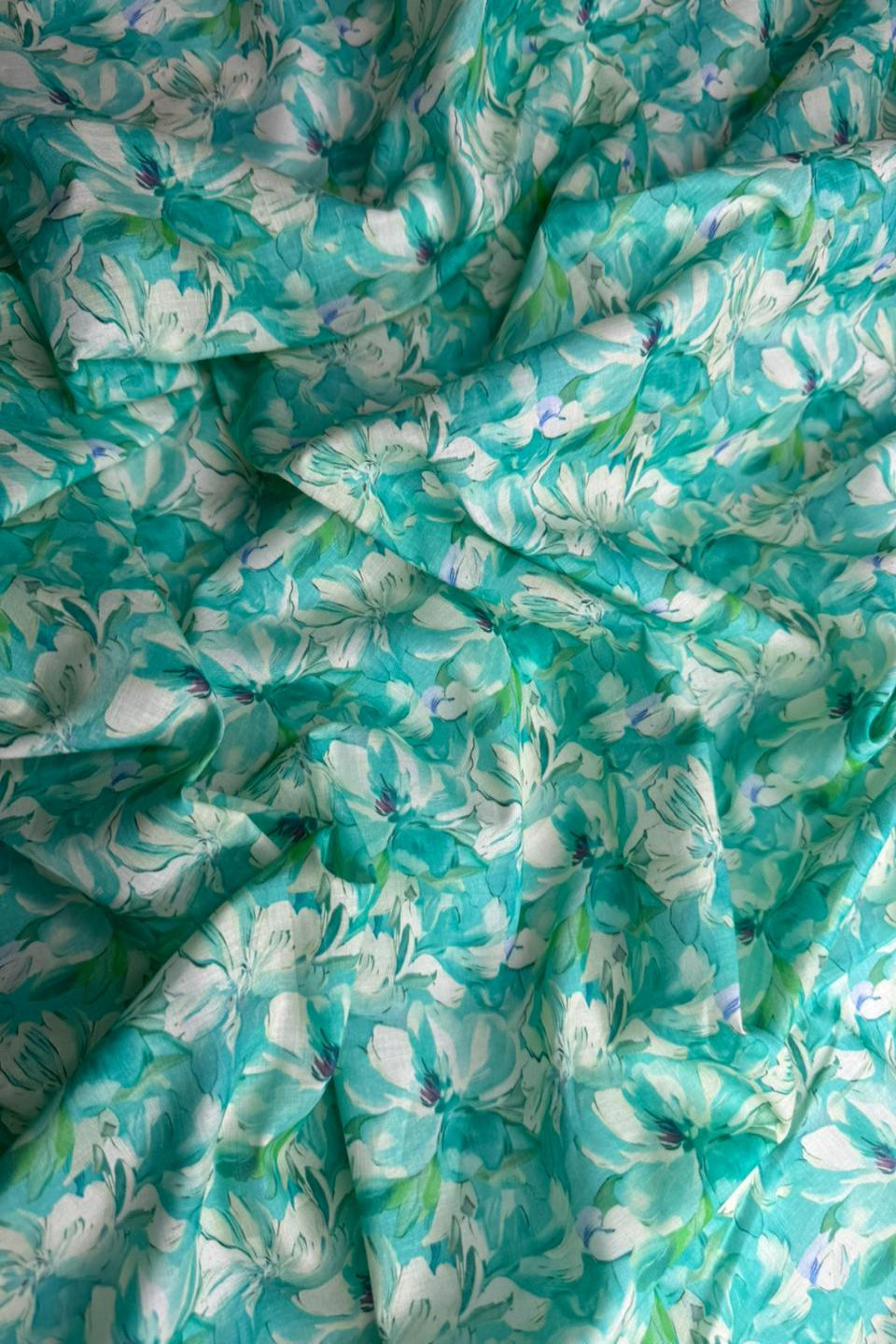 Close-up of teal fabric with white floral pattern