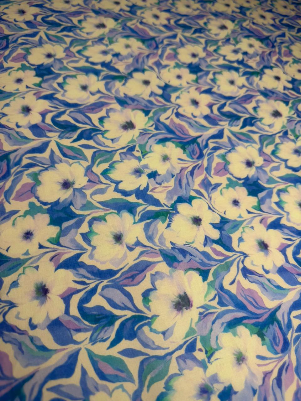 Floral patterned fabric with white flowers on a blue and green background