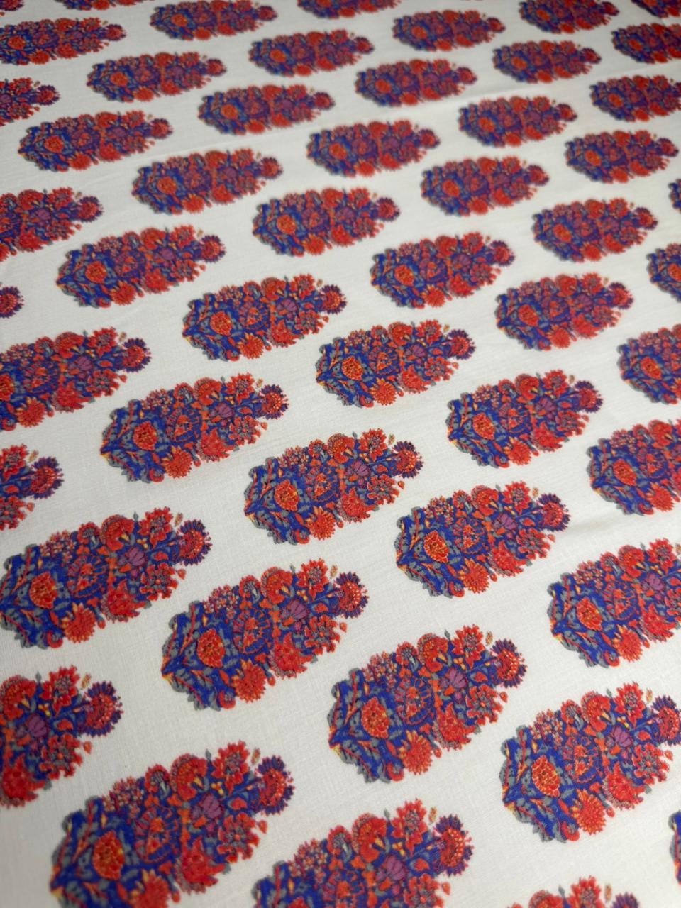 Patterned fabric with red and blue floral design on a white background