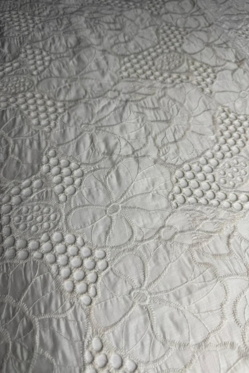 Close-up of textured white fabric with embossed patterns