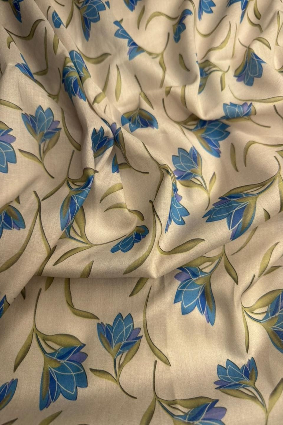 Floral patterned fabric with blue flowers on a beige background
