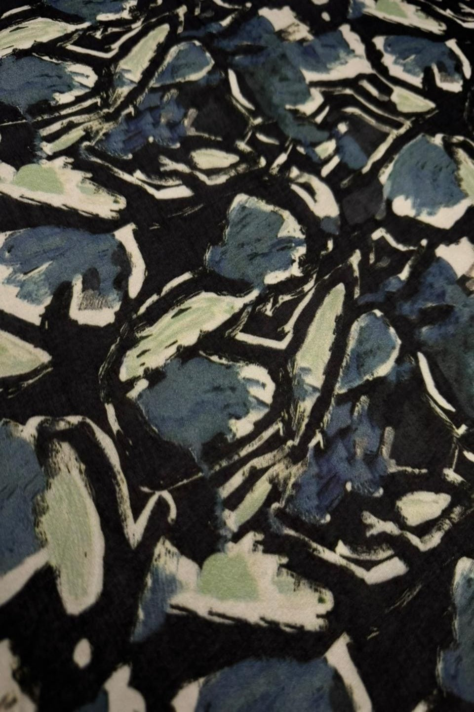 Abstract pattern with blue and green shapes on a black background