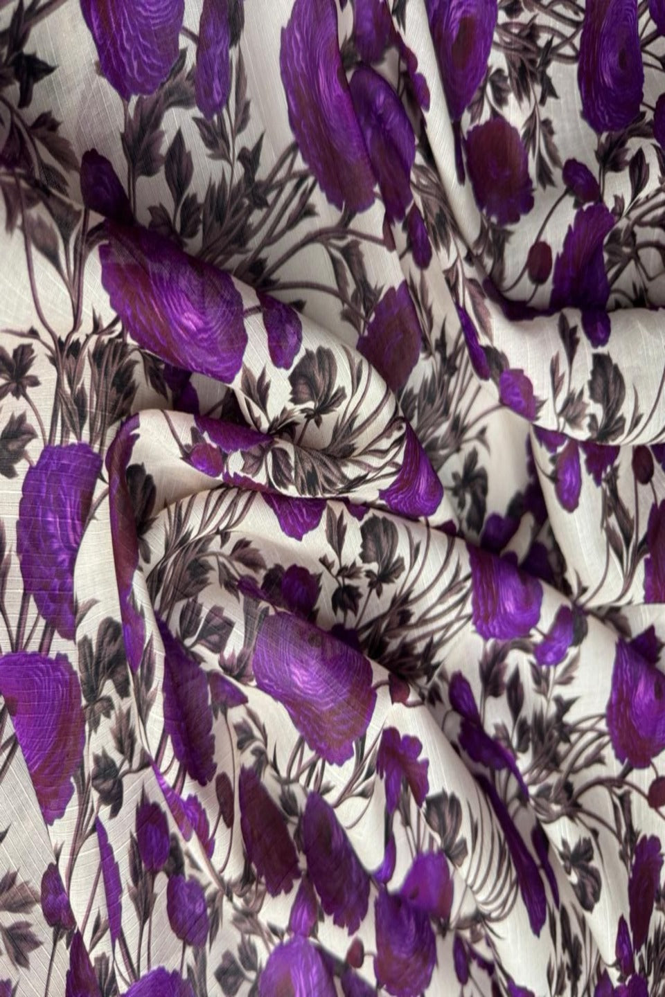 Close-up of a fabric with purple floral pattern on white background