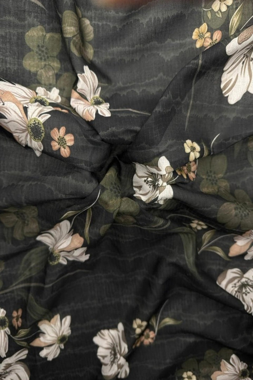 Floral fabric with white, green, and brown flowers on a dark background