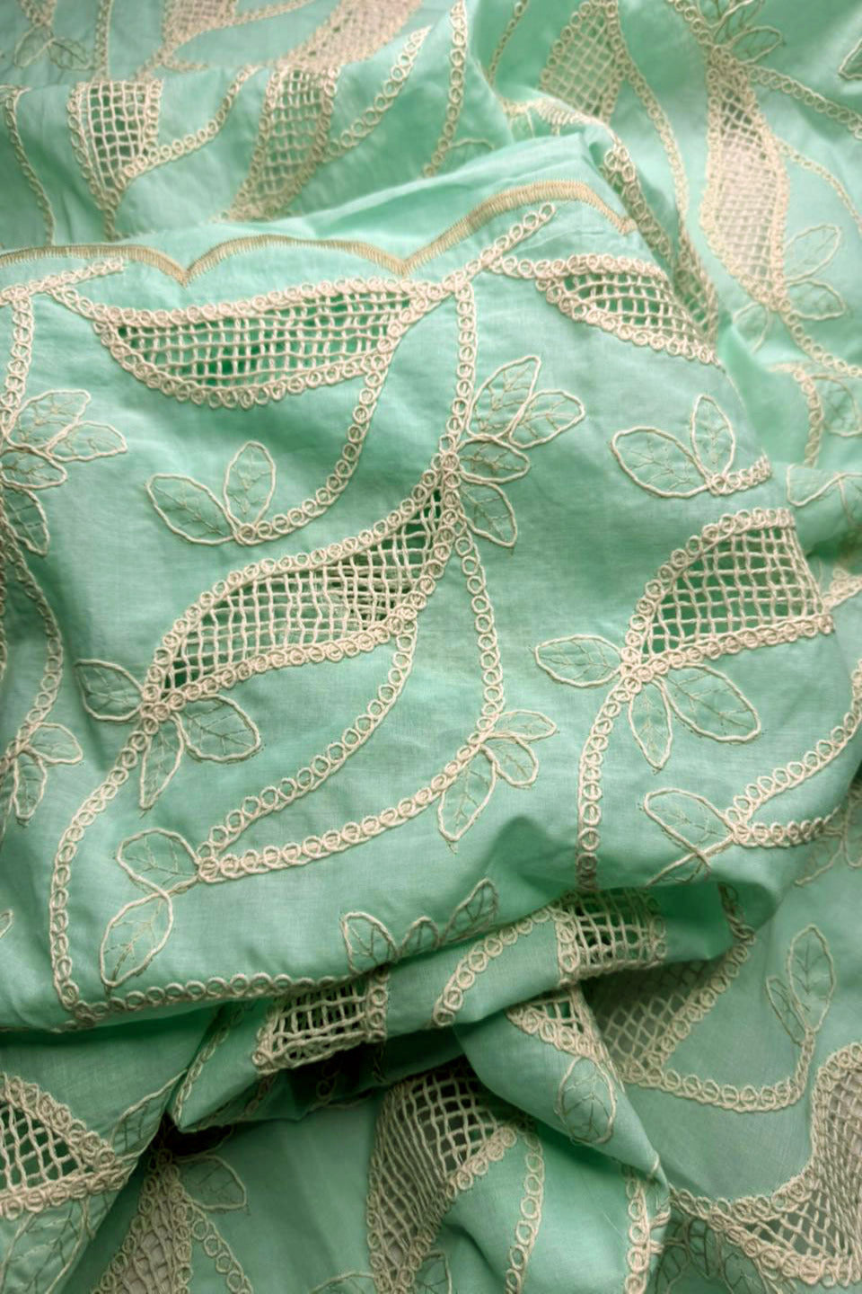 Close-up of green fabric with gold embroidery
