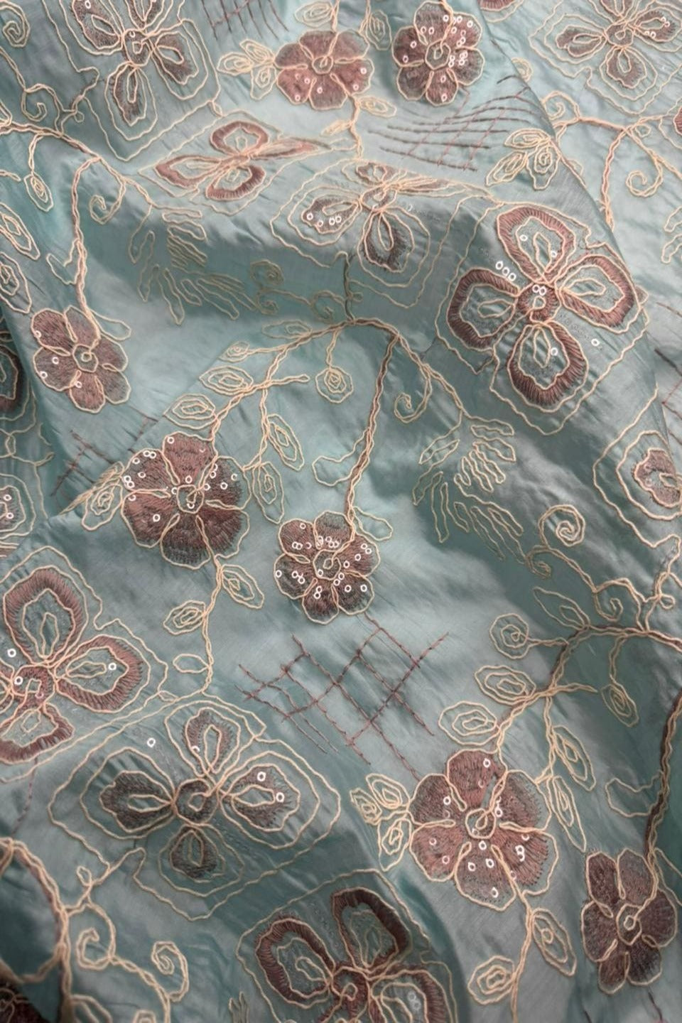 Close-up of embroidered fabric with floral patterns on a textured background