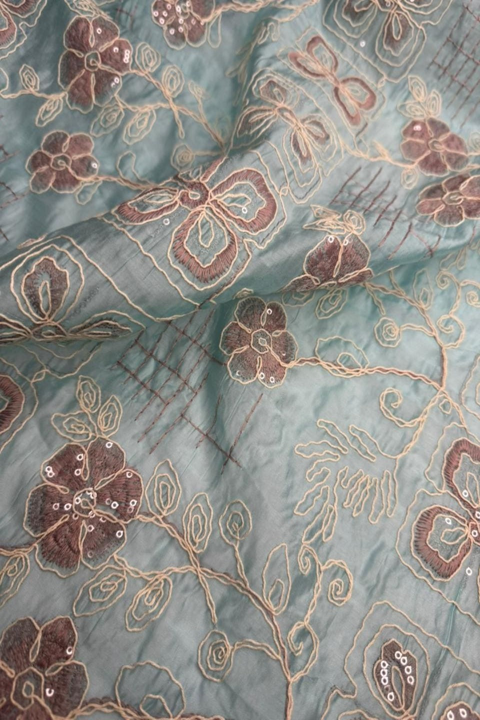 Close-up of floral and paisley patterned fabric with a teal background
