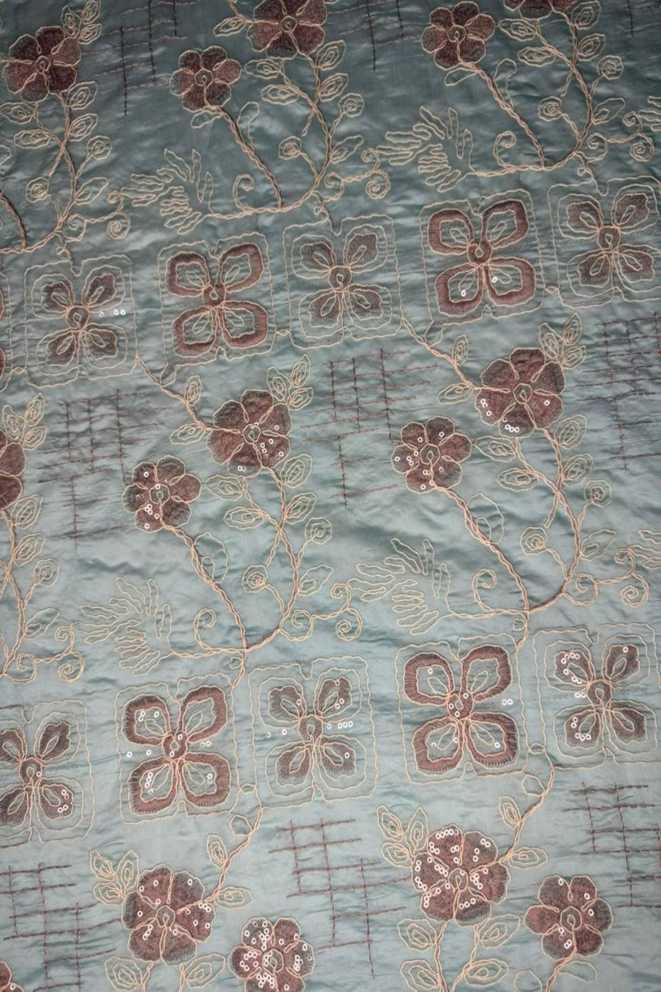 Textile with floral embroidery on a textured fabric background