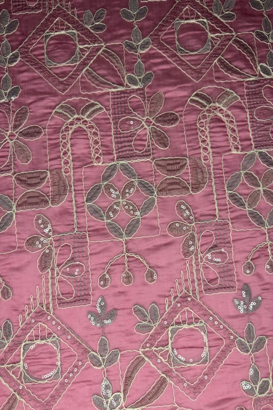 Pink fabric with intricate silver embroidery and patterns