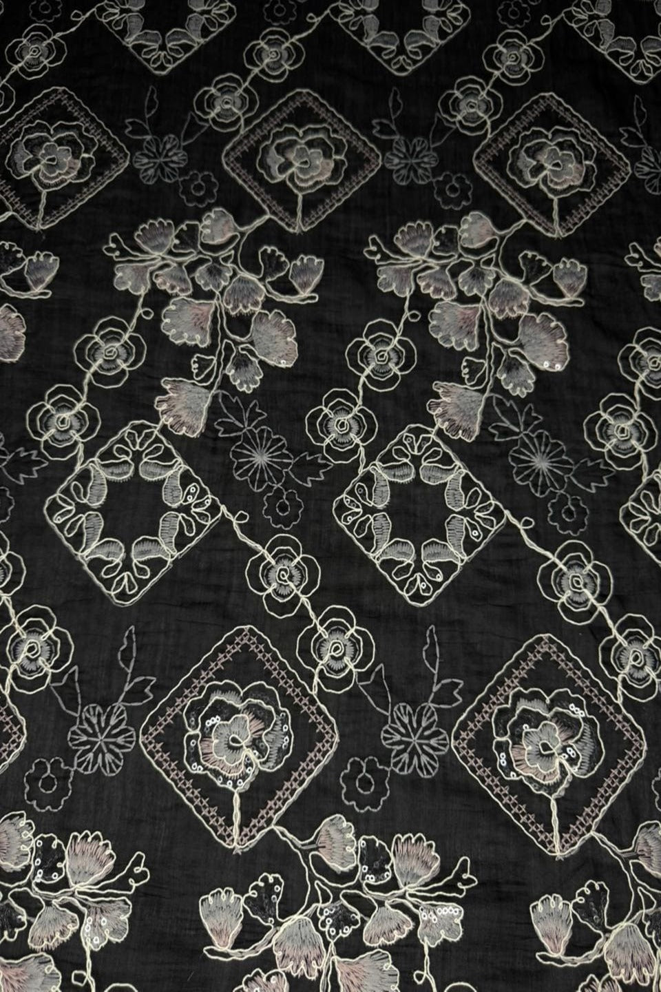 Black fabric with white floral embroidery pattern